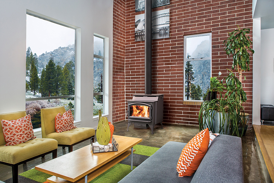 Wood stove fireplace in living room with brick wall